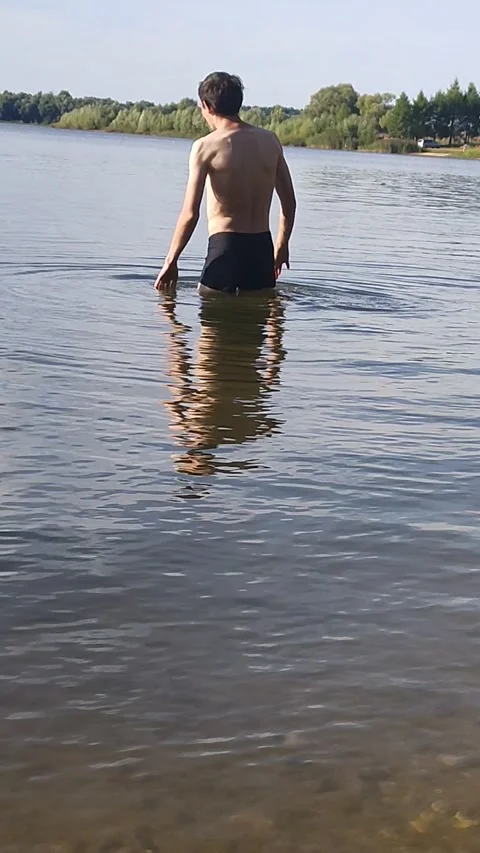 Man is going to swim in the river Stock Footage 208497502