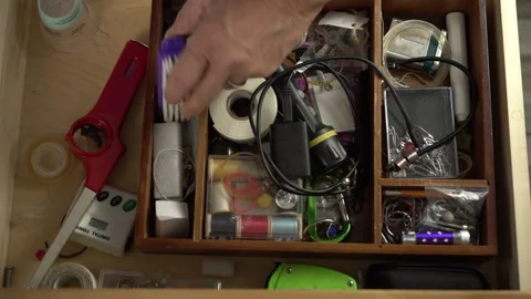 A man going though stuff in a kitchen junk drawer Stock Footage 194513343