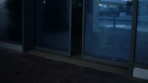 Man going through glass automatic door to the street and roll suitcase on wheels Stock Footage 106200355