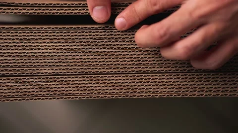 A man is going through a stack of folded brown cardboard Stock Footage 142623528