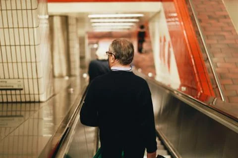 Man going to work at subway station escalator Photos
