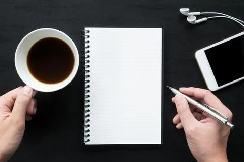 Man is going to write on the notebook. Top view, flat lay. Stock Photos