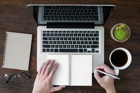 Man is going to write something on a notebook. Top view, flat lay. Stock Photos