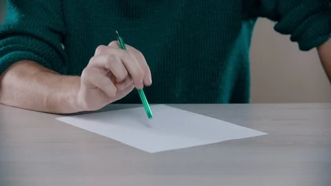 A man is going to write words down on the table Stock Footage 118477431