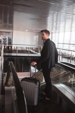 Man goingto the lower level using the escalator Stock Photos