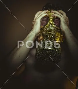 Man with gold gas mask and arabesques in poses of drowning and desperation, d Stock Photos