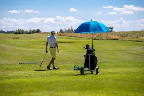 Man on the golf course getting ready to play visible golf cart and beautiful  Stock Photos