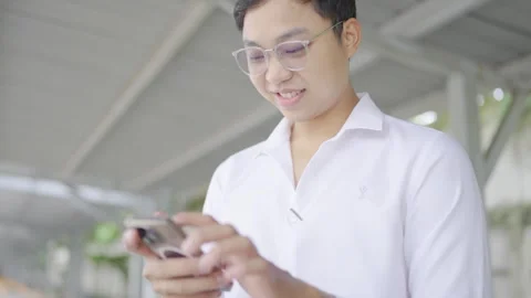 Man in a good mood plays with a cell phone under a building. Stock Footage 251973808