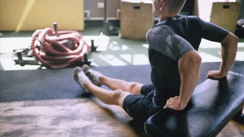 Man in good shape and condition doing triceps dip exercise on bench in gym. Stock Footage 119835587
