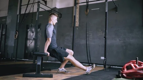Man in good shape doing triceps dip exercise on bench in gym. Stock Footage 119829134