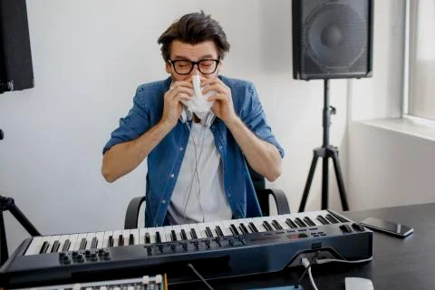 The man got sick. He blows his nose. Composer in the recording studio. music Stock Photos