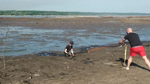 A man got stuck in the silt of the drained Dnieper River. Stock Footage 244220473
