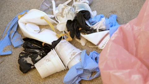 Man grab mask and plastic gloves on seacoast,coronavirus medical waste pollution Stock Footage 134495635