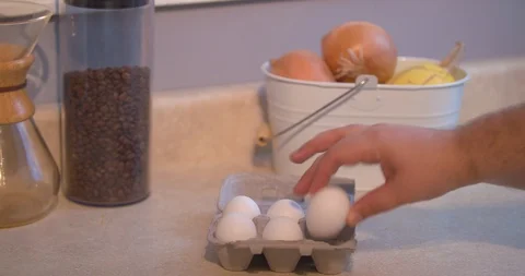 Man Grabbing an Egg out of a Half Dozen Carton Stock Footage 101050372