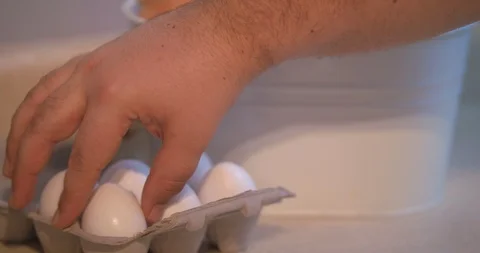 Man Grabbing an Egg out of a Half Dozen Carton Stock Footage 101052824
