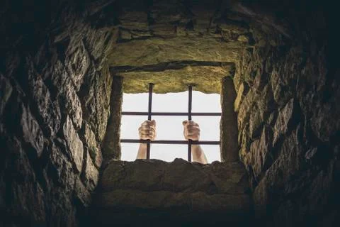 Man grabbing prison bars Stock Photos