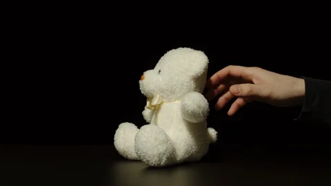 Man Grabbing Small Plush Bear Toy Quietly Off The Black Surface Stock Footage 124623722
