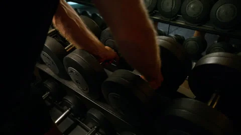 Man grabbing weights in gym Видео 249044799
