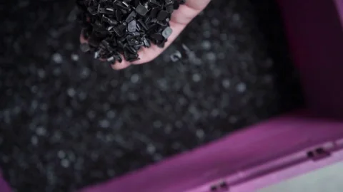 Man Grabs a Hand of Plastic Granules Out of a Container and Strews it out Slowly Vídeos de archivo 118725880