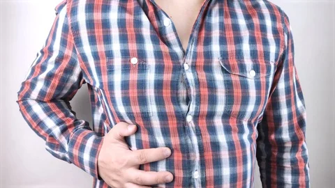 A man grabs his right side under the ribs. Pain in the liver. Pain syndrome in l Video stock 130112499