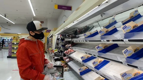 A man grabs the last pack of chicken during a COVID-19 related meat shortage Stock Footage 129507385