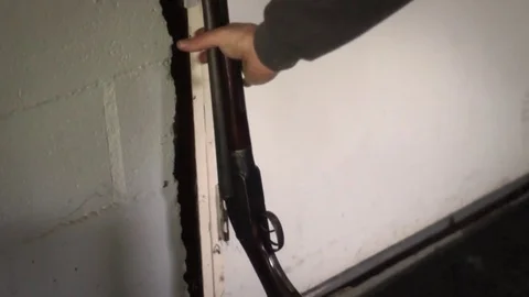 Man grabs old double barrel shotgun from wall - Action movie filler Stock Footage 75013697