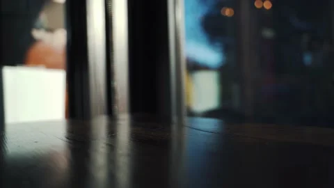Man grabs old fashioned then sets it back down on bar by window Stock Footage 223218440