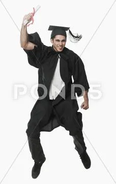 Man in a graduation gown holding a diploma and jumping Stock Photos