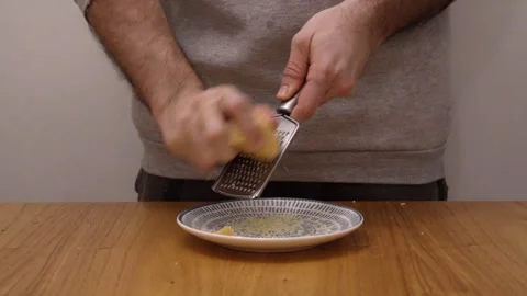 A man grating cheese on the wooden table Stock Footage 282408322