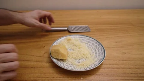 A man grating cheese on the wooden table Stock Footage 282408356