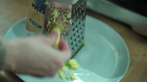 Man grating ginger, grater with ginger for healthy tea lemonade. Stock Footage 304788393