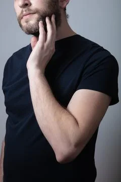 A man with a gray beard suffers from itching and rash on his cheeks Stock Photos