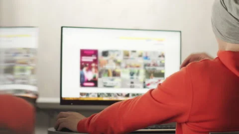 Man in a gray hat works on a computer, reflection on the wall, remote work Stock Footage 152793130