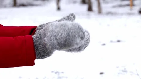 A man in gray knitted mittens makes a snowball in a snowy park.Winter enterainme Stock Footage 301628562