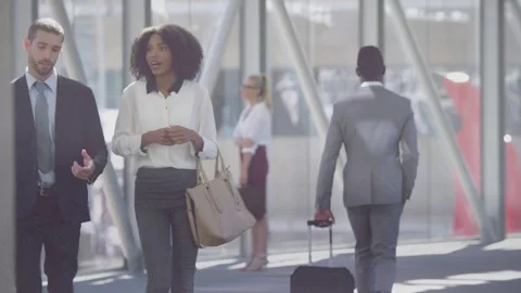 Man in gray suit rolling suitcase walking away, drawing camera to business Stock Footage 333648863