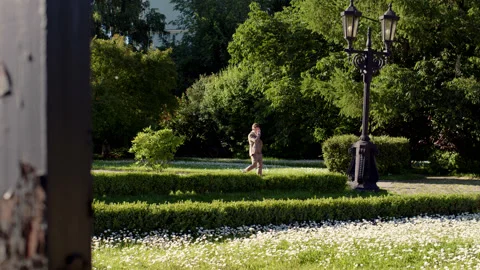 Man in gray suit walks through park. distant view of guy in three-piece suit Stock Footage 239952213