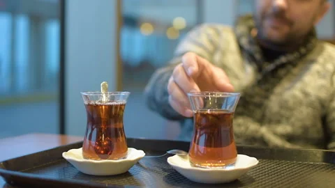 A man in a gray sweater drinks a drink in coffee. Looking out the window. HD Vídeo Stock 100582030
