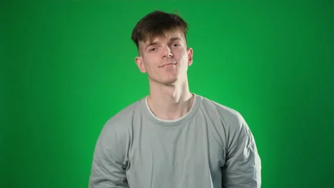 Man in a gray sweatshirt winks looking at the camera 库存影片 224789055