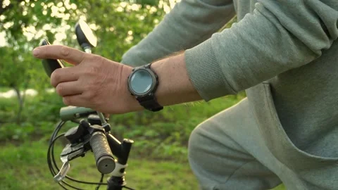 A man in a gray tracksuit adjusts the rearview mirror on his bicycle before Stock Footage 336275670