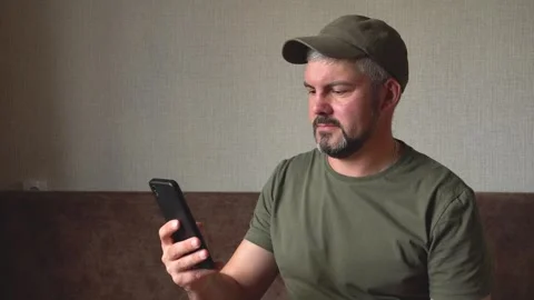 A man in a green baseball cap calls on the phone 4K Stock Footage 274402273