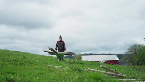 Man On Green Field Setting Posts For Fence. Low Angle Stock Footage 245804194