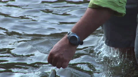 Man In Green Holding His Captured Fish Stock Footage 24704800