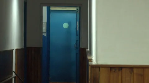 A man in a green jacket walked down an old corridor 스톡 동영상 308824021