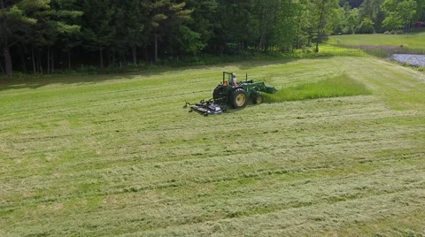 Man on Green John Deer Tractor Cutting Grass Stock Footage 63806419