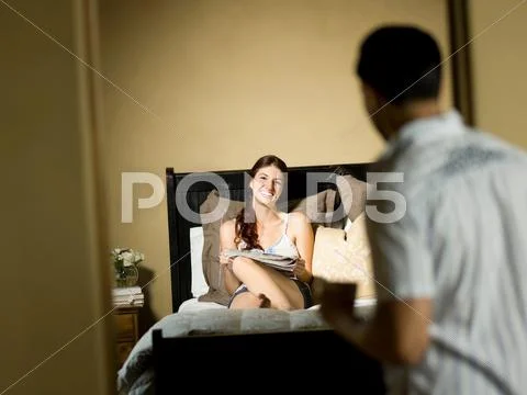 Man Greeting Girlfriend In Bedroom
