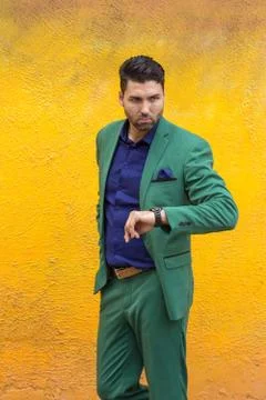 Man in gren suit on yellow wall background. Stock Photos