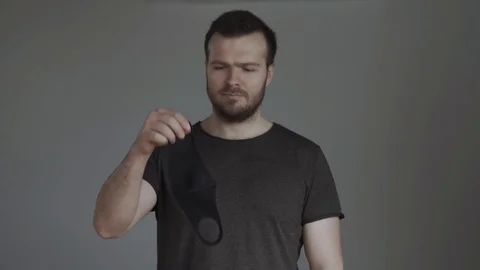 A man on a grey background is wearing a mask. Coronavirus instructions. Safety Stock Footage 129267393