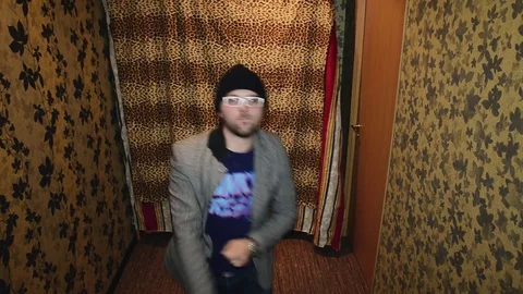 Man in grey coat, black hat, glasses funny dancing in corridor. Parody. Gesture Stock Footage 75315098