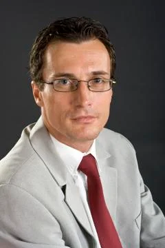 Man in grey jacket with red tie and glasses Stock Photos