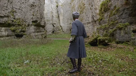 Man in grey papakha and circassian puts dagger into sheath Stock Footage 108167953